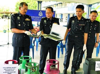 诺依里斯(左)与一众警官示出警方所起获到的手提电脑等物品。